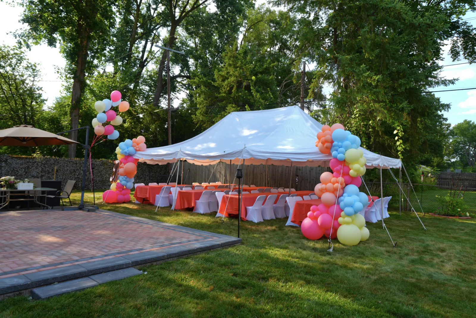 Colorful balloon columns on a backyard tent set for a children's birthday party